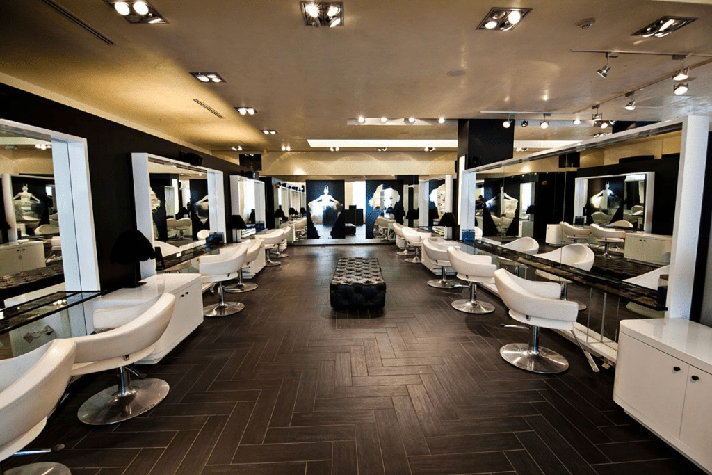 Spacious styling floor with white chairs and mirrors at Aura Beauty Suites salon suites in Colorado Springs.