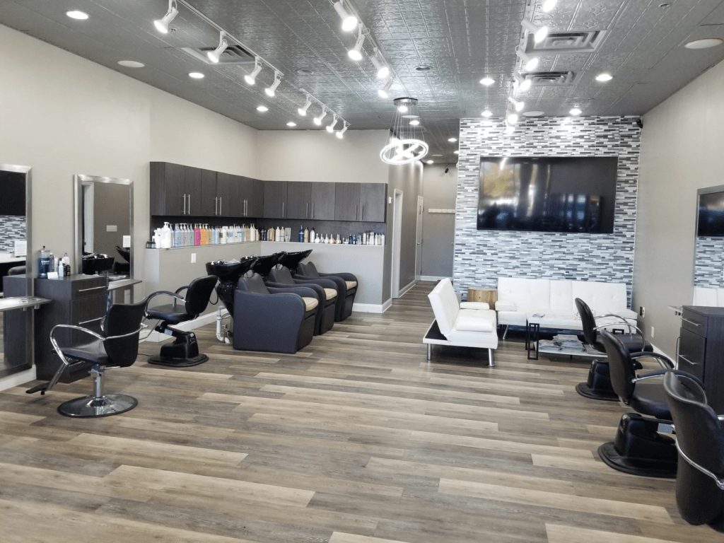 Spacious hair salon interior with shampoo bowls and styling chairs at Aura Beauty Suites salon suites in Colorado Springs.