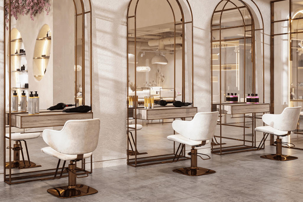Elegant gold-framed styling stations with white chairs at Aura Beauty Suites salon suites in Colorado Springs.